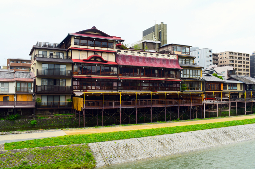 松原橋から。赤い屋根の建物が鮒鶴。 北側（写真右側）の3階建てが「本館」。その南側の楼閣建築が「新館」です。
