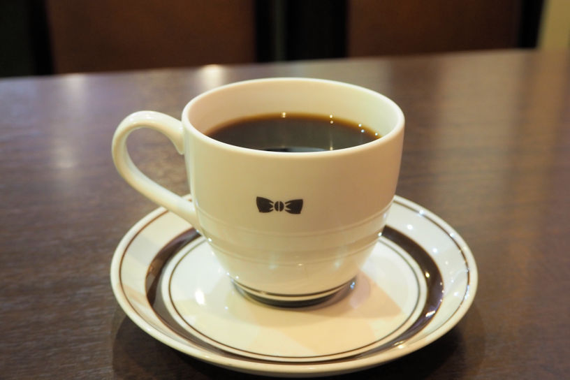 リボンのワンポイントがかわいいコーヒーカップ。ドリンクはコーヒー・紅茶・オレンジジュース・カフェオレ（＋50円）から選べます。
