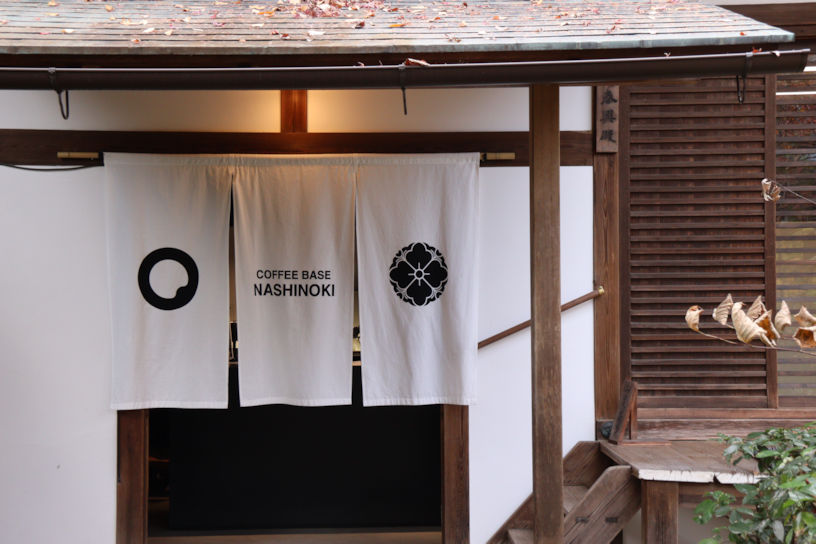 のれんには、Coffee Baseのロゴ（左）と梨木神社の御神紋（右）をデザイン