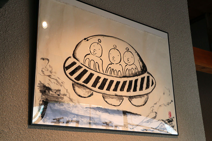 店名にあわせて飾られている鈴木一太郎さんの作品。宇宙人のつぶらな瞳がかわいい！