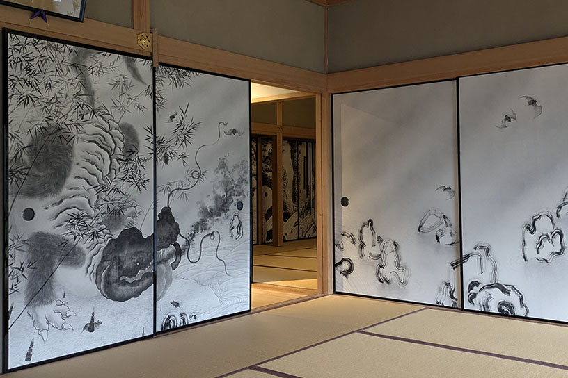 達磨大師と対峙するように描かれるのは、丹羽作品の代表的なモチーフである「虎狼鯰（コロナマズ）」