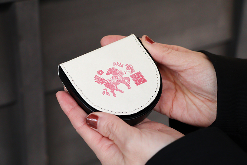 オリジナル馬蹄型コインケース。表面は「よみがえれ！富士山の火のうま」、裏面は「翔け出せ！神馬の京都吉祥めぐり」（写真）のデザインです